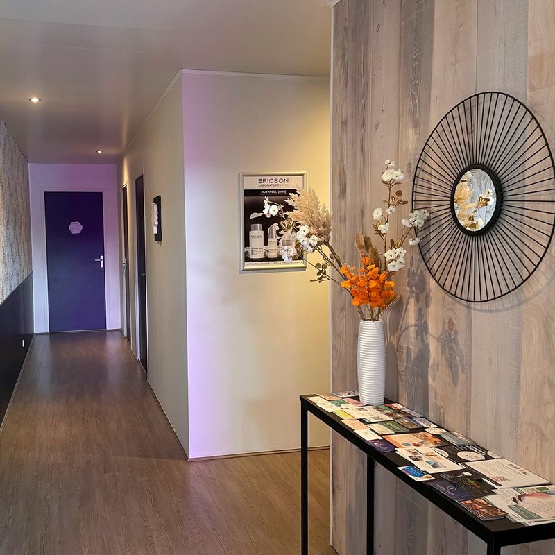 Couloir de l'institut vers les cabines, miroir en soleil et bouquet de fleurs