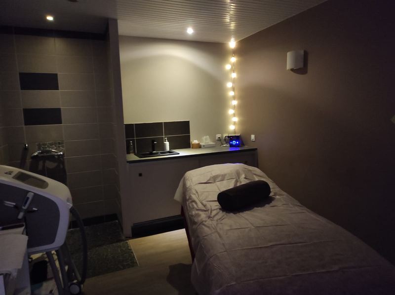 Cabine de massage tamisée, guirlande lumineuse au mur