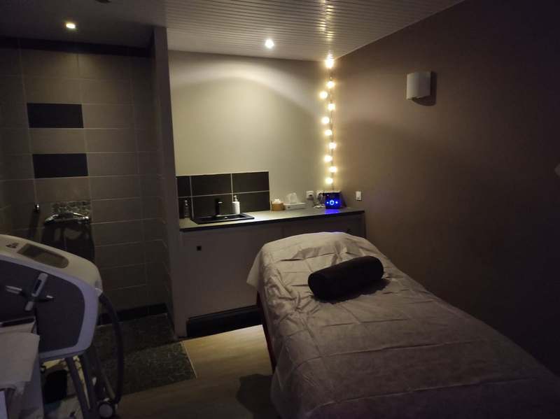 Cabine de massage tamisée, guirlande lumineuse au mur