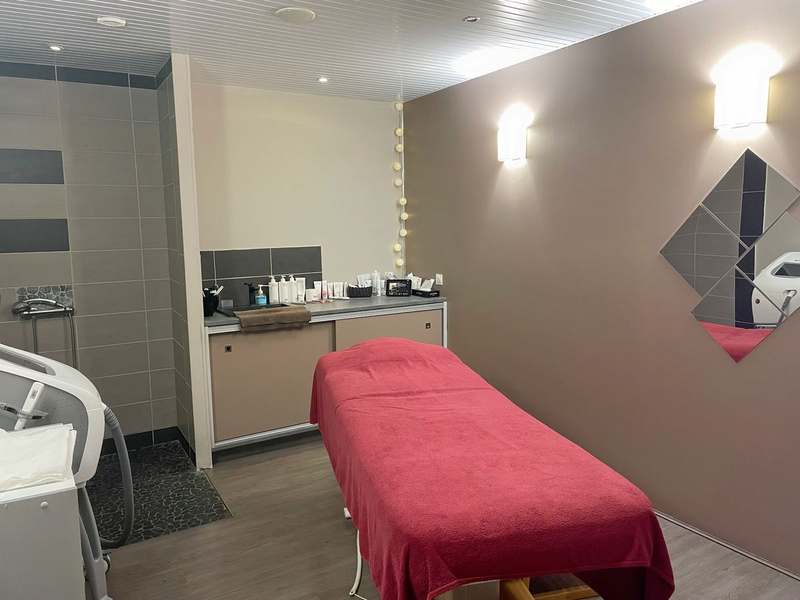 Cabine aux murs taupe avec son plan de travail et sa table de soins