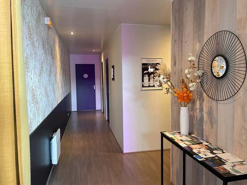 Couloir de l'institut vers les cabines, miroir en soleil et bouquet de fleurs